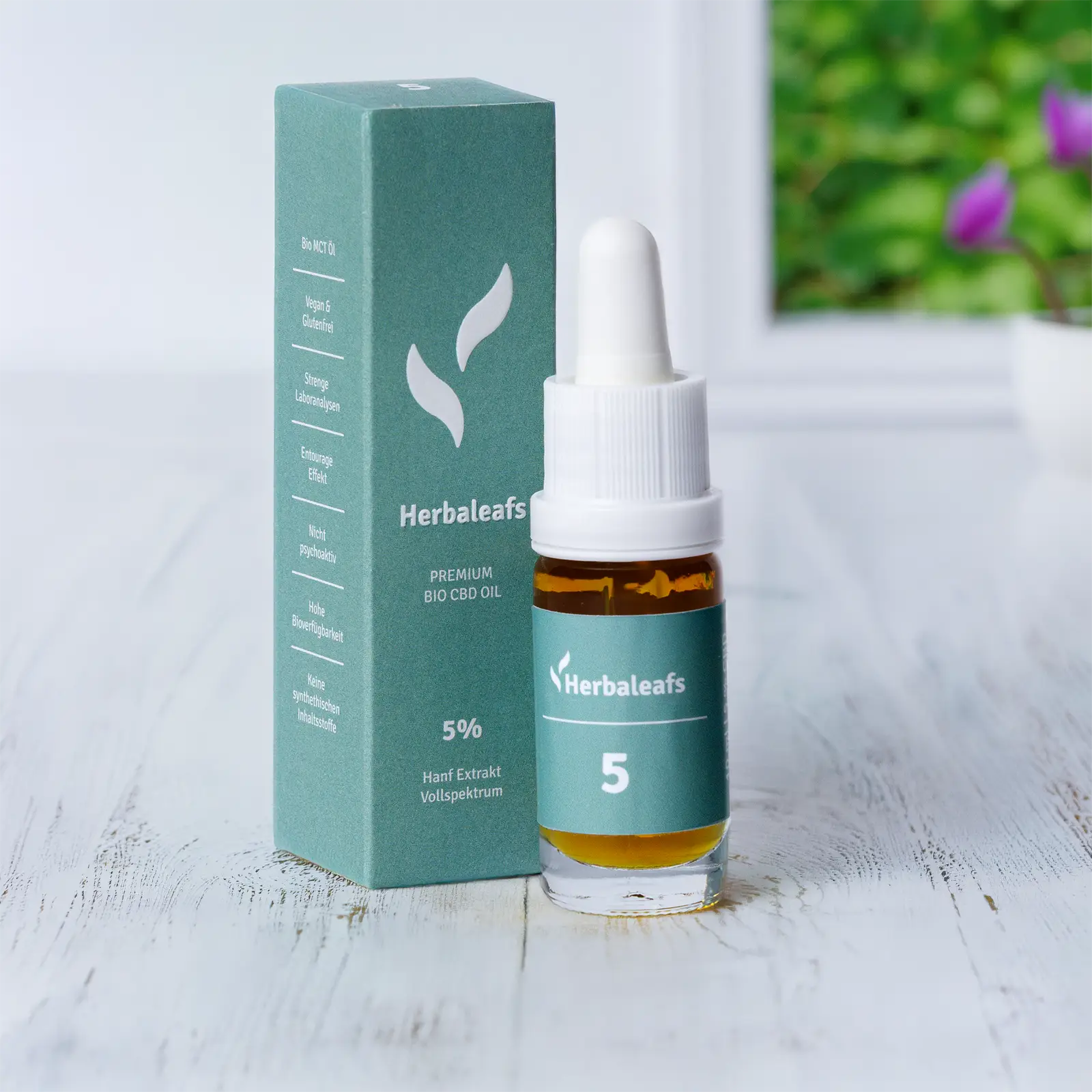 Eine Flasche CBD Öl 5 % steht auf dem Parkettboden.