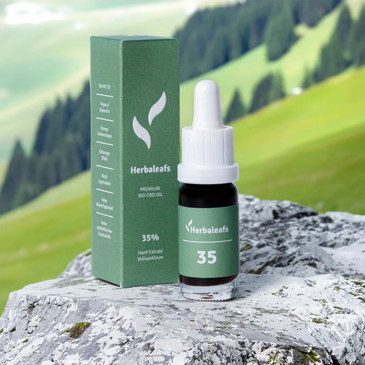 Eine Flasche CBD-Öl 35 % auf einem Stein an einem steilen Berghang.